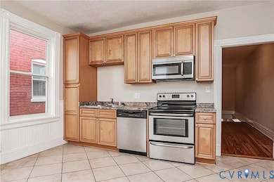 Kitchen with stainless steel appliances and dark stone counters