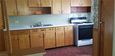 Kitchen with sink, gas range gas stove, decorative backsplash, and light brown cabinets