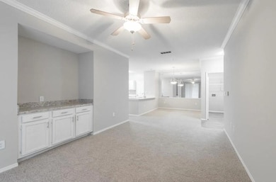 Unfurnished living room with ceiling fan, crown mo