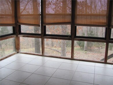 Enclosed back porch with view of peaceful back yard.