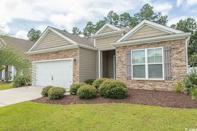 View of front of home featuring stone siding, a front lawn, concrete driveway, a garage, and roof with shingles