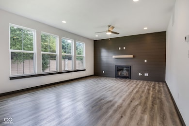 unfurnished living room with a large fireplace, recessed lighting, and a ceiling fan