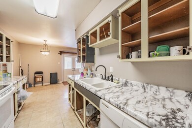 Kitchen with hanging light fixtures, white applian
