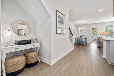 Hall with a notable chandelier, stairs, recessed lighting, baseboards, and light wood-type flooring