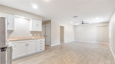 Kitchen featuring light countertops, freestanding refrigerator, white range oven, white cabinetry, and ceiling fan