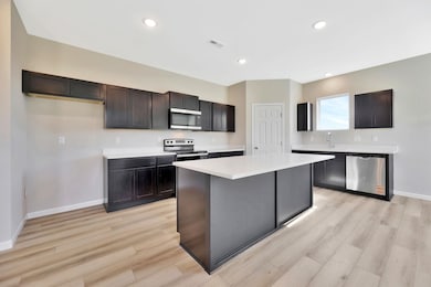 Kitchen featuring stainless steel appliances, light wood-style floors, recessed lighting, and a center island