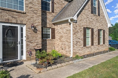 Doorway to property with roof with shingles and br