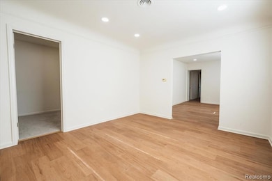 Empty room featuring light wood-style flooring and recessed lighting