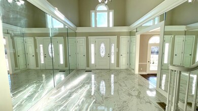 Entrance foyer featuring a high ceiling, baseboard