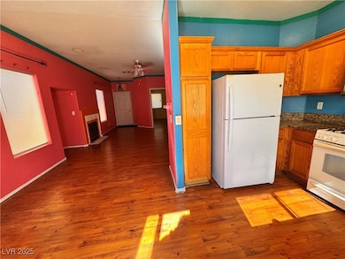 Kitchen featuring white appliances, dark wood finished floors, ceiling fan, brown cabinets, and heating unit