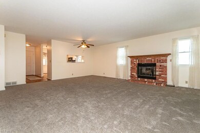 Living room featuring a fireplace, light carpet, a