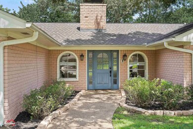 Entrance to property with a shingled roof, a chimney, and brick siding