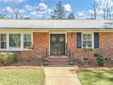 Property entrance featuring metal roof and brick s