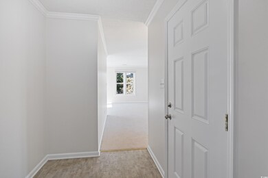 Corridor with light wood-type flooring and crown m