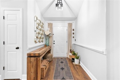 Entrance foyer featuring lofted ceiling and hardwo