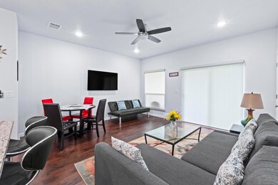 Living area with wood finished floors, ceiling fa