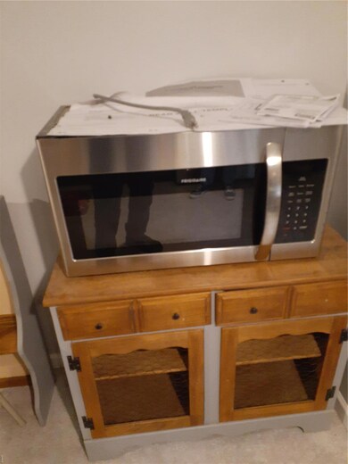 Room details featuring stainless steel microwave and brown cabinets