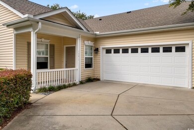 View of front of house featuring a garage and a po