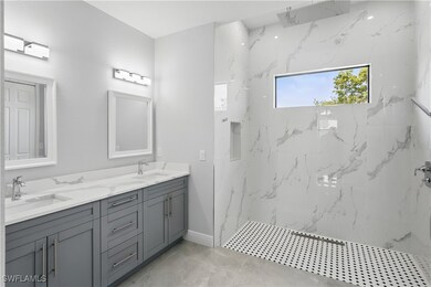 Full bath featuring marble finish floor, double va