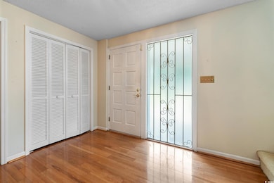 Foyer entrance with a textured ceiling and light h