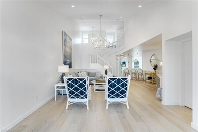 Dining area featuring light wood-style floors, recessed lighting, a towering ceiling, a chandelier, and stairway