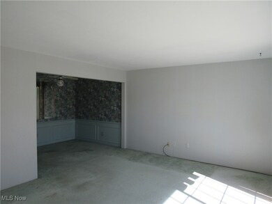 Carpeted empty room with a wainscoted wall and a decorative wall