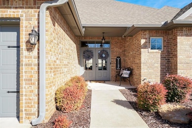 View of exterior entry with a garage, french doors