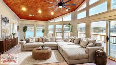 Living area with wood ceiling, a water view, ceiling fan, light wood-type flooring, and high vaulted ceiling