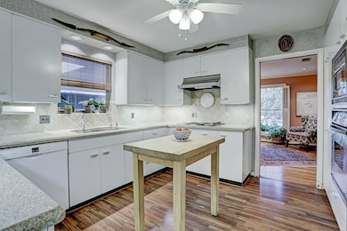 The Kitchen cabinets have great under-counter lighting, Silestone counter tops and popular tile back splash. The Dishwasher was recently replaced.  For those who enjoying cooking a lot, the ceiling fan helps keep the kitchen cool.  This back of photo shows the formal living room.  (Chopping block table was personal property and removed.)