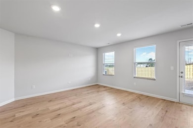 Unfurnished room with light wood-style flooring, plenty of natural light, baseboards, and recessed lighting