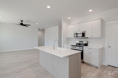 Kitchen featuring stainless steel appliances, light wood-style floors, recessed lighting, light countertops, and a ceiling fan