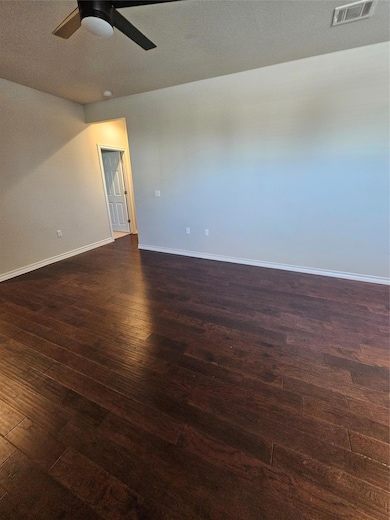 Spare room featuring dark wood finished floors and a textured ceiling