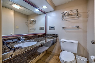 Bathroom featuring toilet, tile patterned floors, and vanity