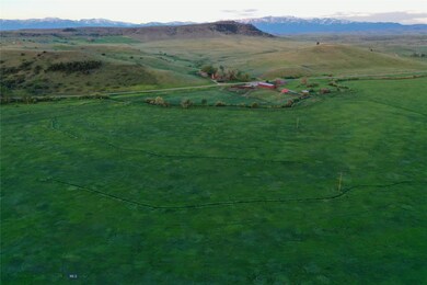 Looking southwest across eastern hayfield, buildin