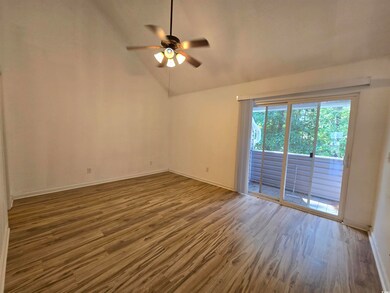 Unfurnished room featuring ceiling fan, vaulted ce