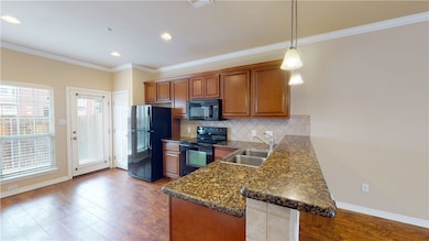 Kitchen with black appliances, a sink, brown cabin