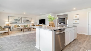 Kitchen featuring white cabinets, light stone countertops, open floor plan, dishwasher, and recessed lighting