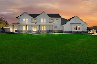 Back house at dusk featuring a yard, a porch, and 