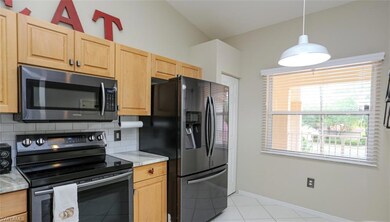 Kitchen with light stone counters, lofted ceiling,