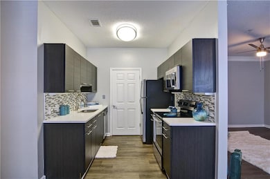 Kitchen featuring decorative backsplash, appliances with stainless steel finishes, and hardwood / wood-style floors