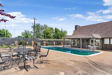 Community pool with fence, clubhouse and a patio a