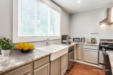 Kitchen featuring wall chimney range hood, applian