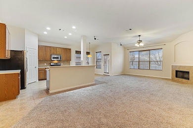 Kitchen featuring brown cabinets, open floor plan, light countertops, tasteful backsplash, and light carpet
