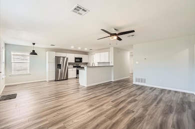 Unfurnished living room featuring ceiling fan and