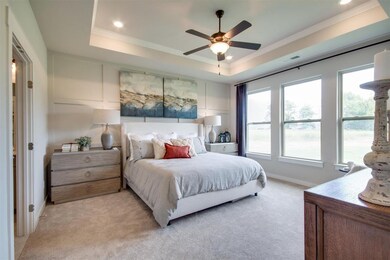 Master bathroom has tray ceiling with crown molding and an included fan.
