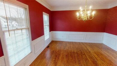 Formal dining room with wood flooring.