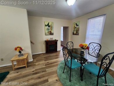 Dining space with wood finished floors, healthy amount of natural light, and a fireplace
