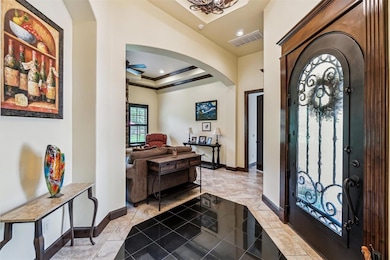 Entryway with arched walkways, a ceiling fan, baseboards, ornamental molding, and recessed lighting