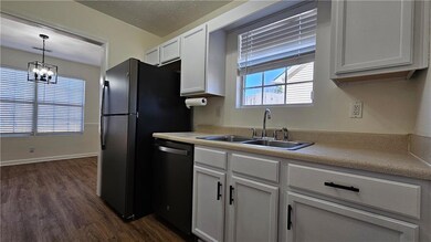 Kitchen featuring dark wood finished floors, dishw