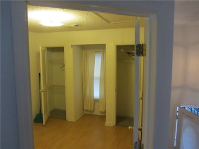 Corridor featuring baseboards, a textured ceiling,